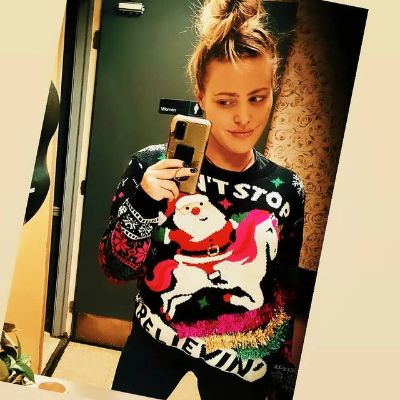 She is wearing a Christmas sweater in the picture.